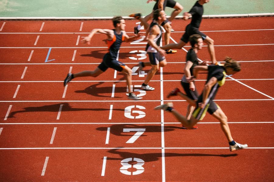Athletes cross the finish line on a running track