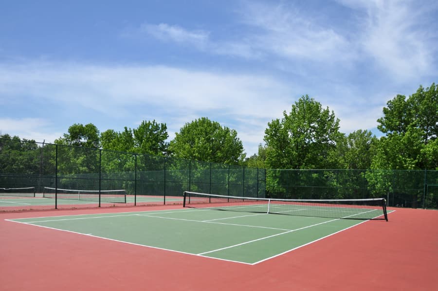 Empty Tennis Court With Surrounding Fence