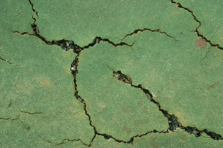 Close-up view of a cracked tennis court surface