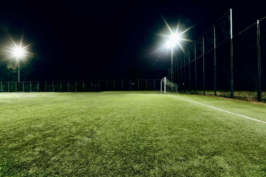 Gorgeous synthetic turf soccer field lit up under stadium lights
