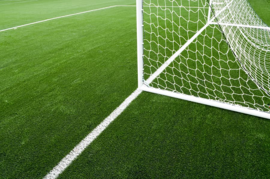 Soccer net and lines on bright green artificial turf field